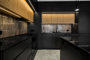 Czarna kuchnia z drewnem w nowoczesnej zabudowie na wymiar