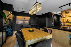 Kuchnia czarna i jadalnia z drewnianym stołem