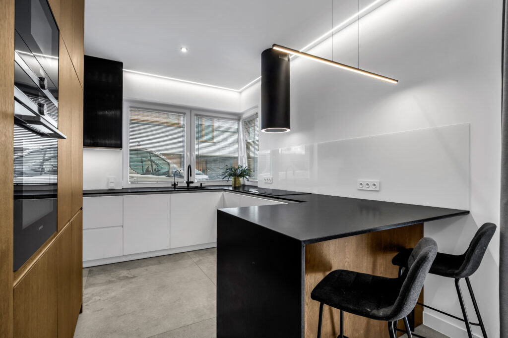 Kuchnia na wymiar z nowoczesnym półwyspem i zabudową pod sufit.