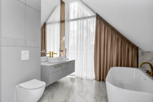 Biała łazienka z ryflowaną szafką umywalkową i szafką nad WC wykonanymi na wymiar.