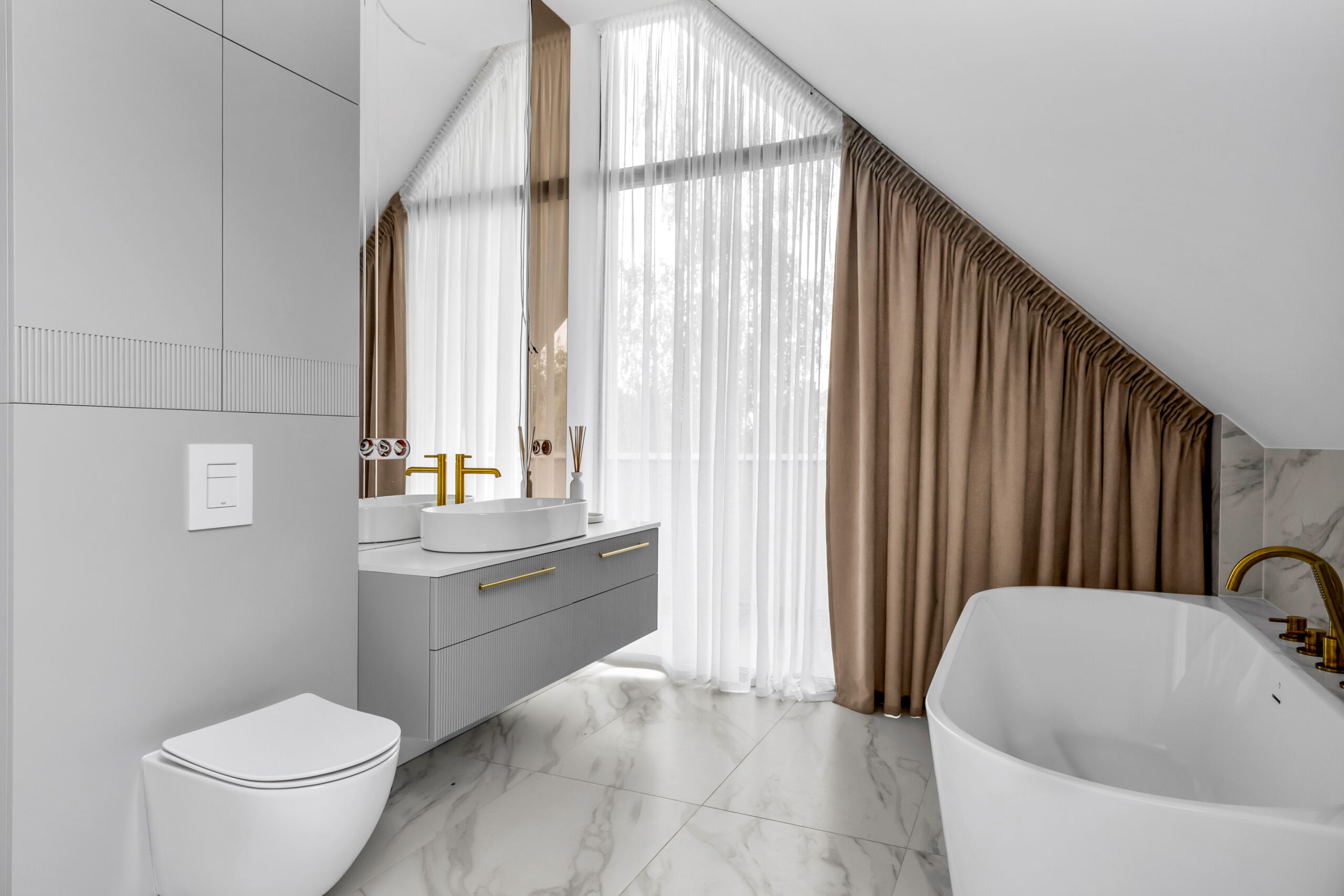 Biała łazienka z ryflowaną szafką umywalkową i szafką nad WC wykonanymi na wymiar.