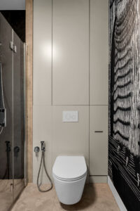 Biała zabudowa WC wykonana na wymiar w nowoczesnej łazience.