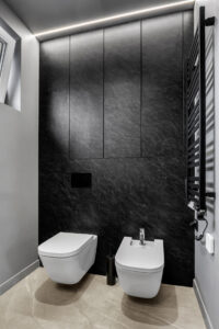 Czarna zabudowa WC wykonana z płyty laminowanej na wymiar.