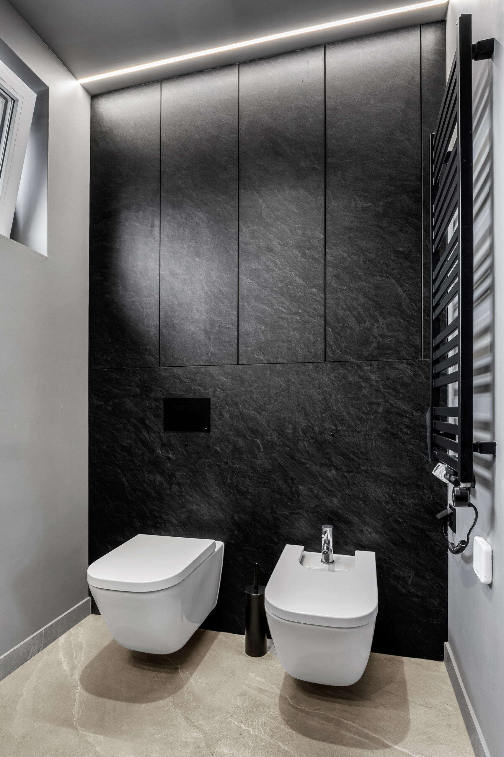 Czarna zabudowa WC wykonana z płyty laminowanej na wymiar.