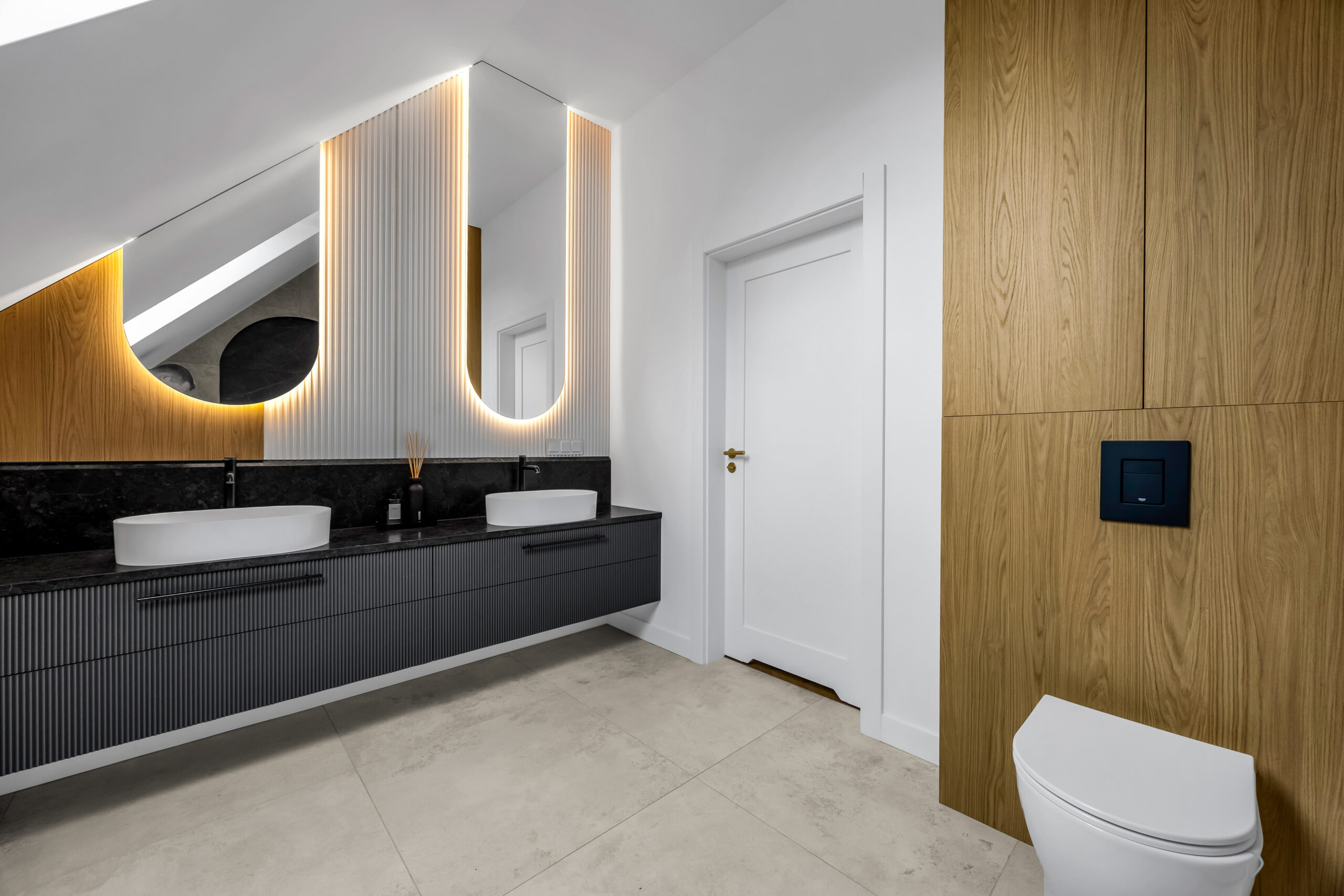 Czarna łazienka na wymiar z ryflowaną szafką umywalkową i drewnianą zabudową nad WC.