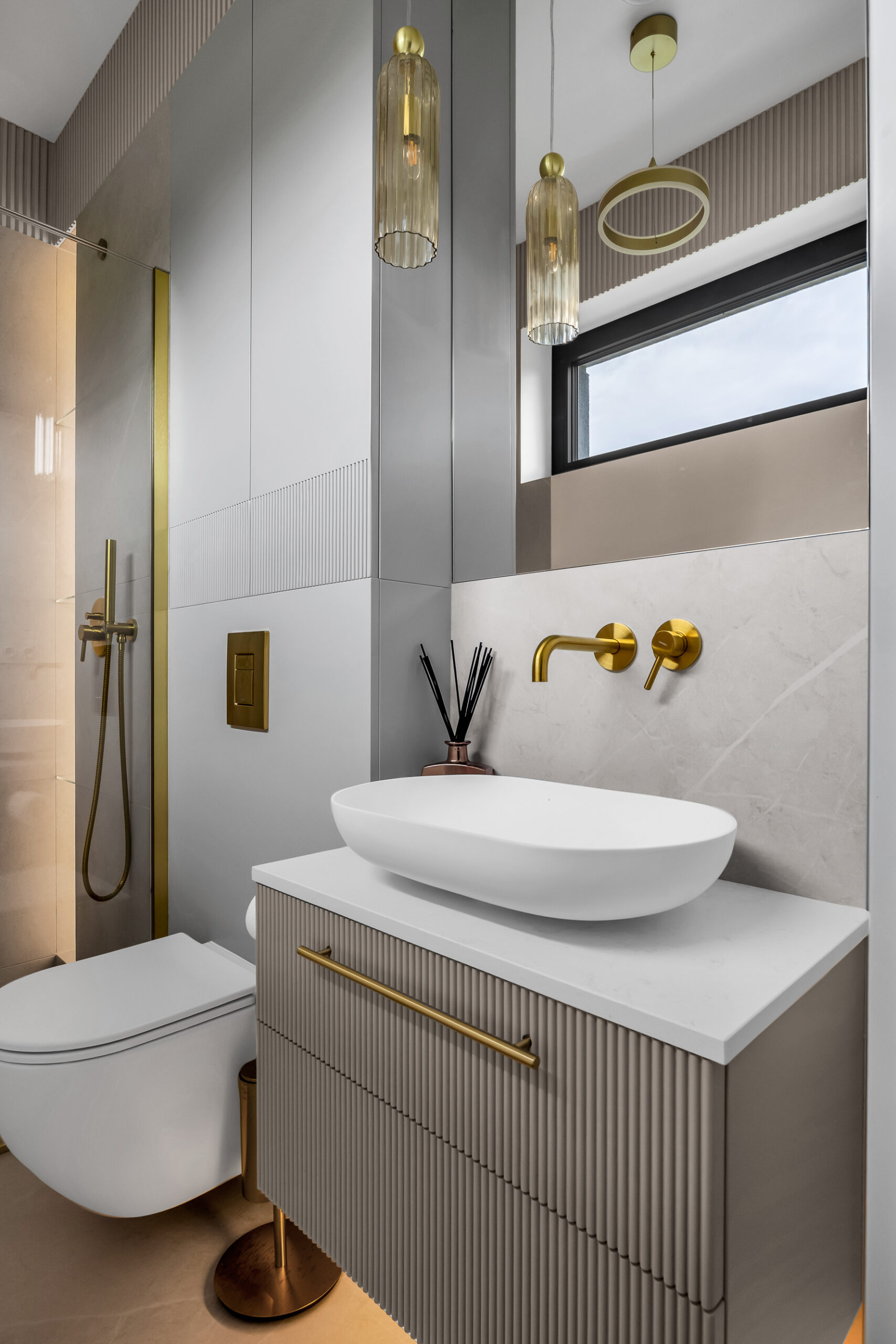 Kaszmirowa łazienka z elegancką ryflowaną szafką umywalkową wykonaną na wymiar.