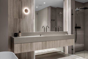 Kolejne ujęcie łazienki premium z kamieniem naturalnym i lakierowaną zabudową na wymiar.