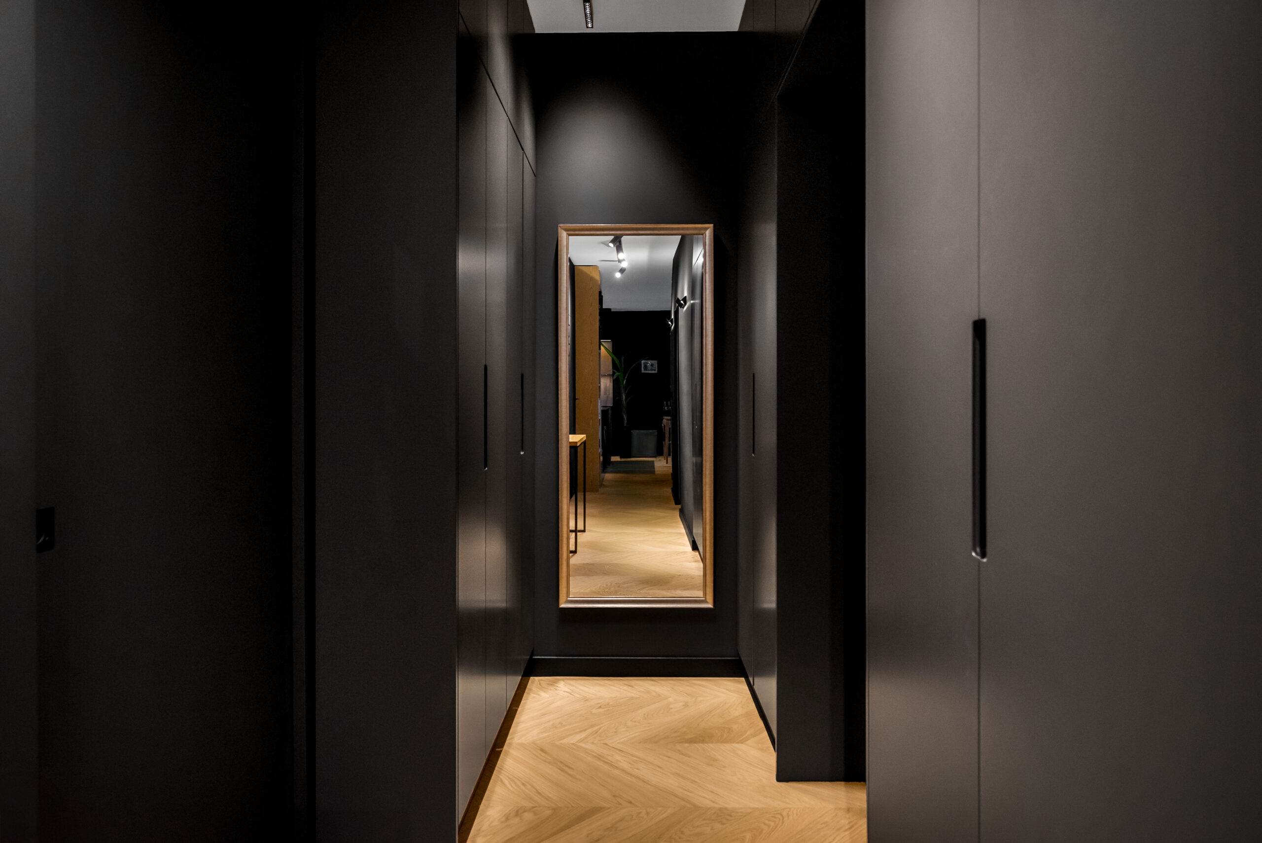 Czarne lakierowane szafy na wymiar w nowoczesnym przedpokoju.