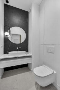 Minimalistyczna biała zabudowa w WC.