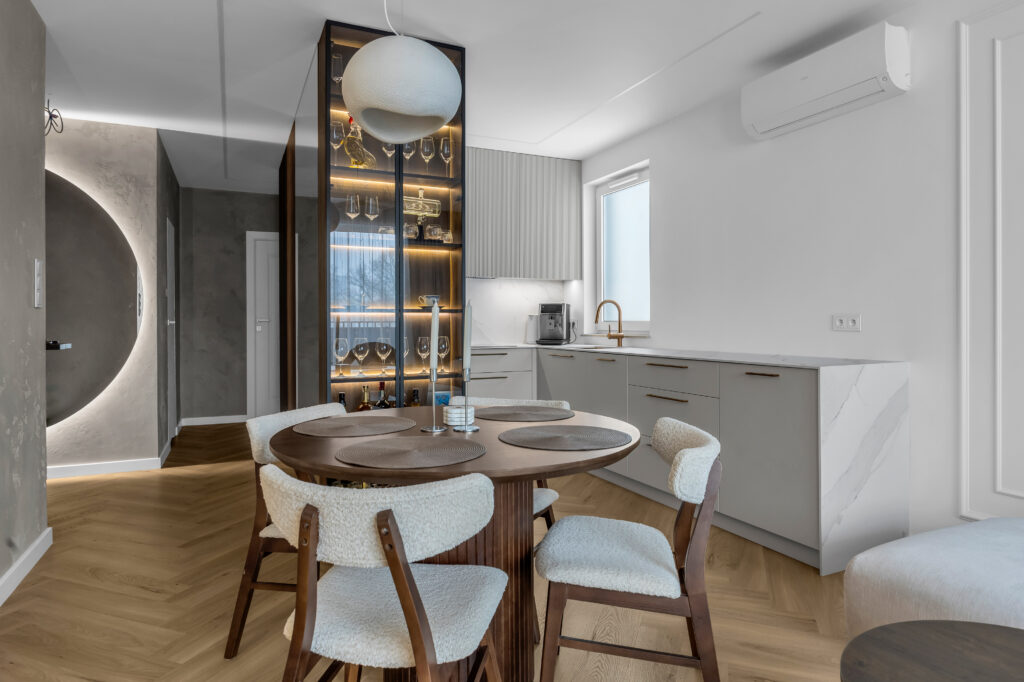 Kuchnia na wymiar połączona wizualnie z zabudową przedpokoju wykonaną z drewna.