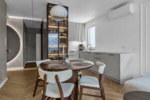 Kuchnia na wymiar połączona wizualnie z zabudową przedpokoju wykonaną z drewna.