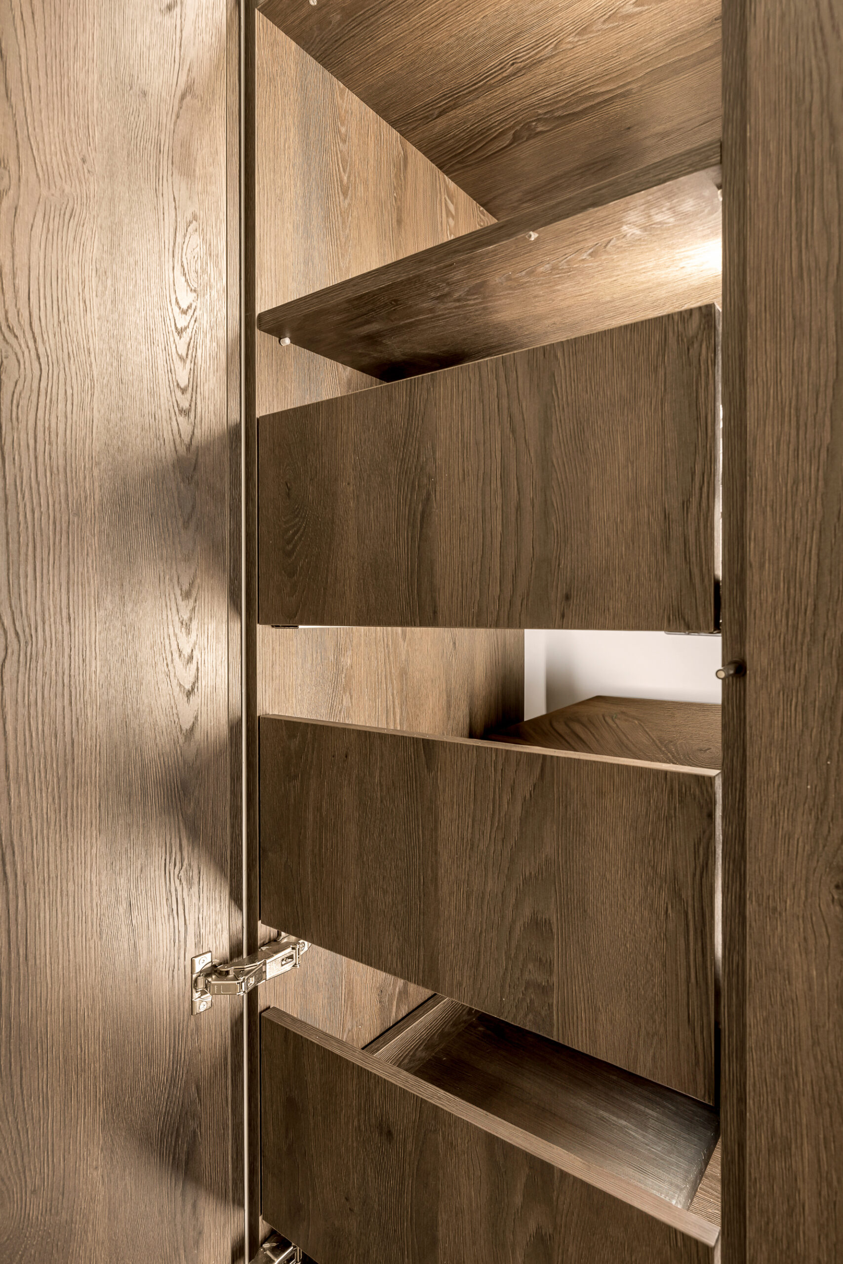 Wnętrze szafki na wymiar z wysuwanym systemem cargo na buty w przedpokoju.