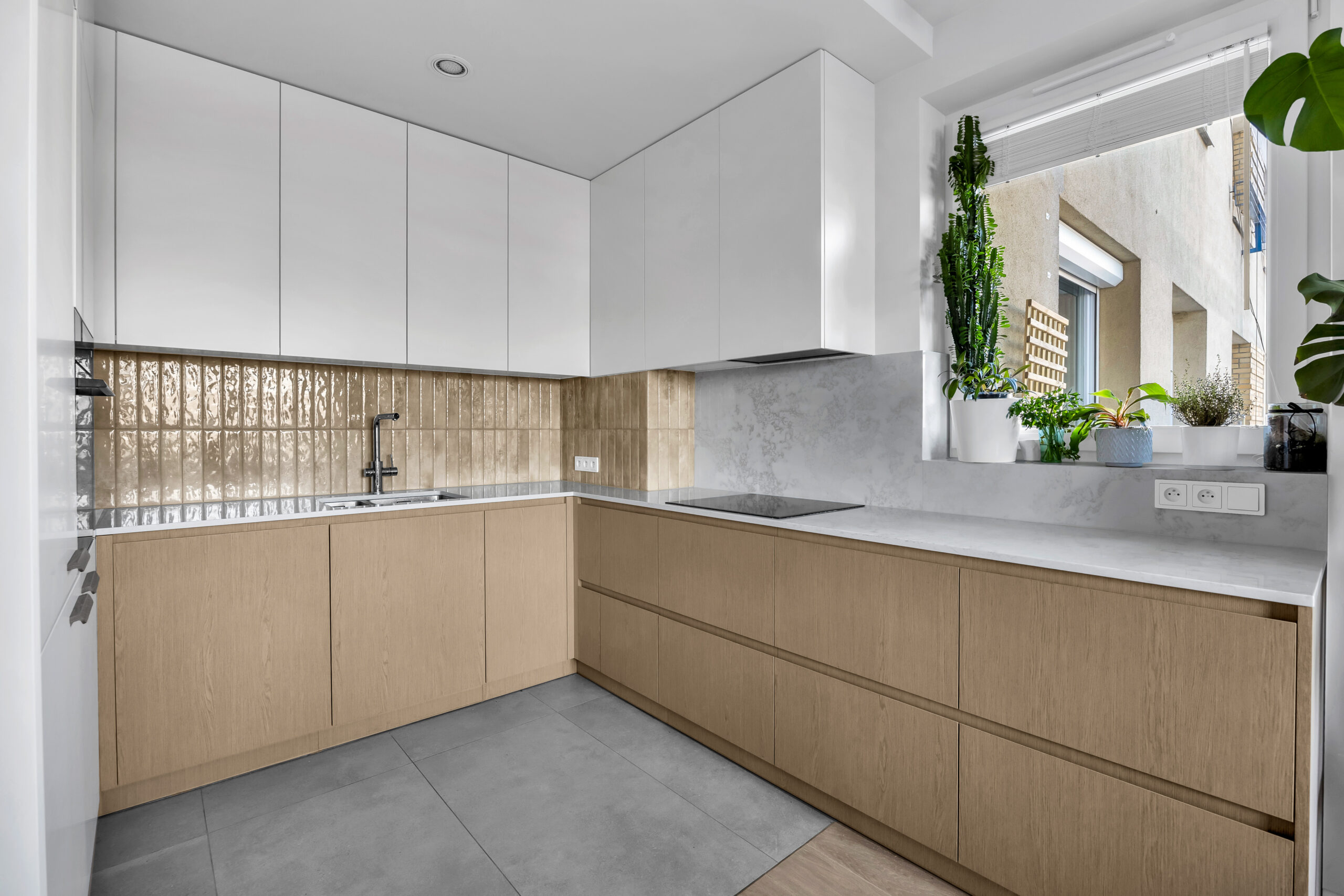 Kuchnia z blatem poprowadzonym na ścianie oraz drewnianą zabudową dolną.