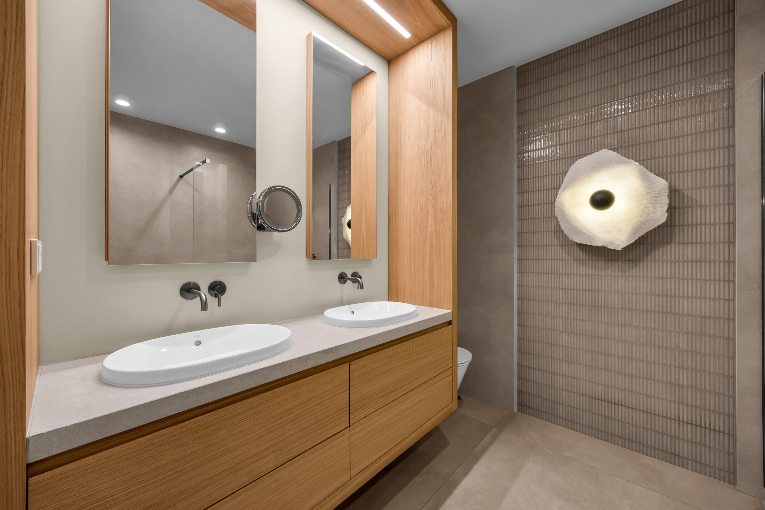 Nowoczesna łazienka z meblami na wymiar i drewnianą zabudową.