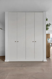 Szafa na ubrania na wymiar z białymi frontami w przedpokoju.